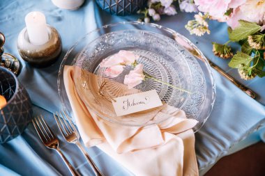 Şeftali çiçekleri ve konuk kartında bu mavi masada açık kristal yemekleri