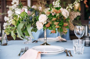 Yükseklik gümüş Vazoda Çiçekler ile dekore edilmiş mavi masa örtüsü ile Festival tablo