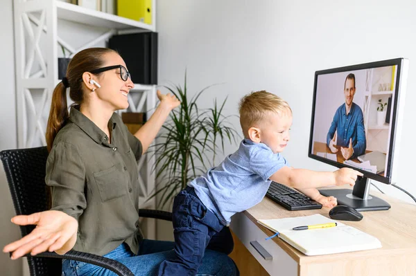 Mère travaille au bureau à la maison avec un enfant sur les tours — Photo