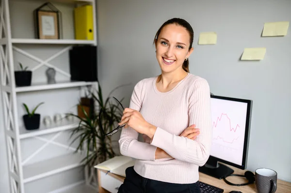 Lächelnd brünett mädchen looks im camera standing im home office — Stockfoto