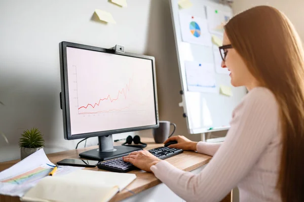 Jonge vrouw is met behulp van PC voor het werk van thuis uit kantoor — Stockfoto