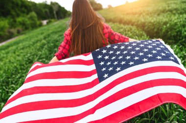 Kadın Amerikan bayrağıyla sahada koşuyor.
