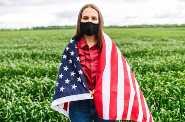 Üzgün kız kendini bir Amerikan bayrağına sarmış.
