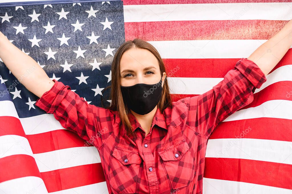 Girl wearing face mask holding US flag