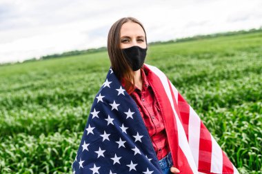 Üzgün kız kendini bir Amerikan bayrağına sarmış.