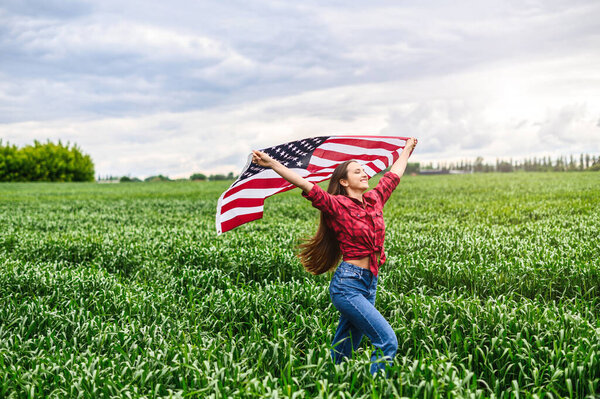 Woman is running through the field with USA flag
