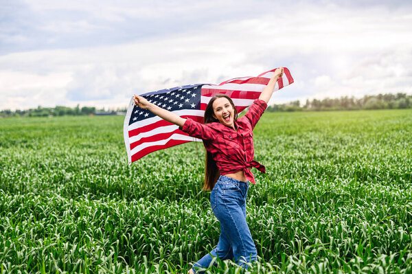 Woman is running through the field with USA flag