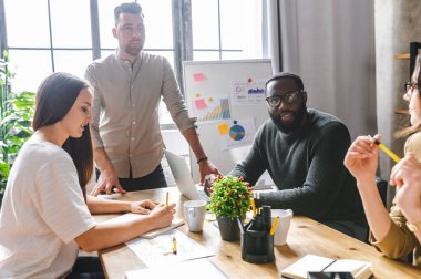 Genç ciddi çeşitli iş arkadaşları iş stratejisi üzerinde çalışıyor.