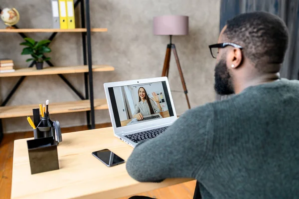 A guy talking online with employees via video call