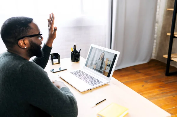 A guy talking online with employees via video call