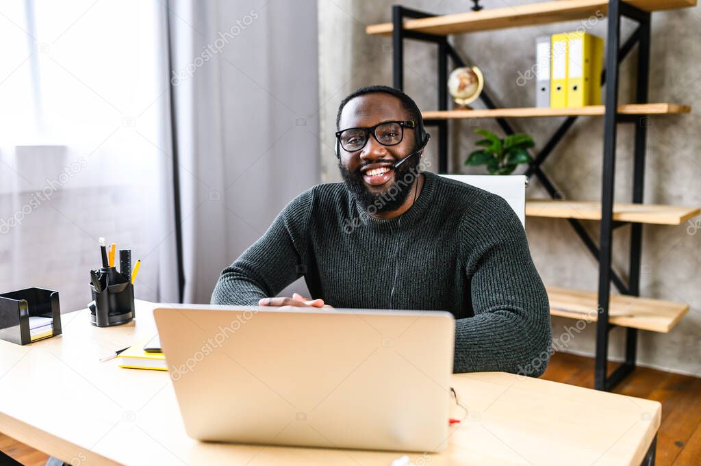 African-American guy with headset using laptop