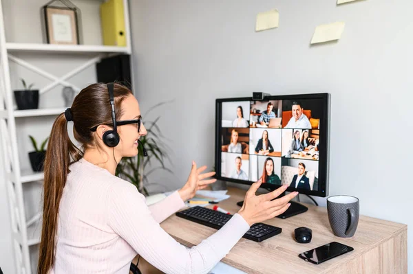 Žena se sluchátky rozhovory online se zaměstnanci — Stock fotografie