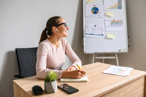 Mulher fazendo anotações na mesa do escritório — Fotografia de Stock