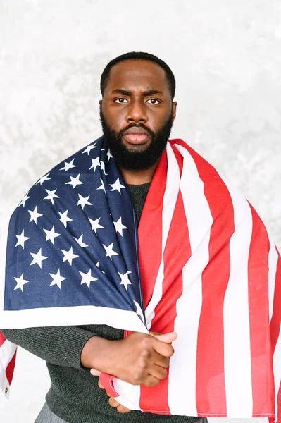 African-American guy stands with US flag