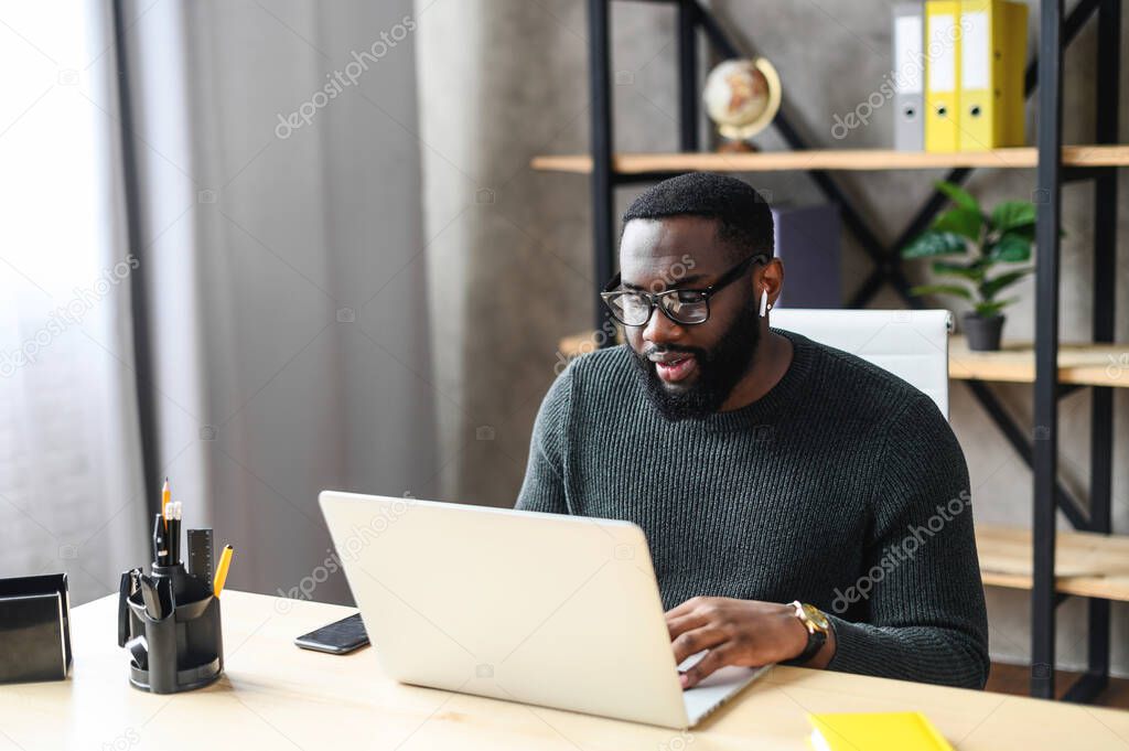 An African-American guy using laptop in the office