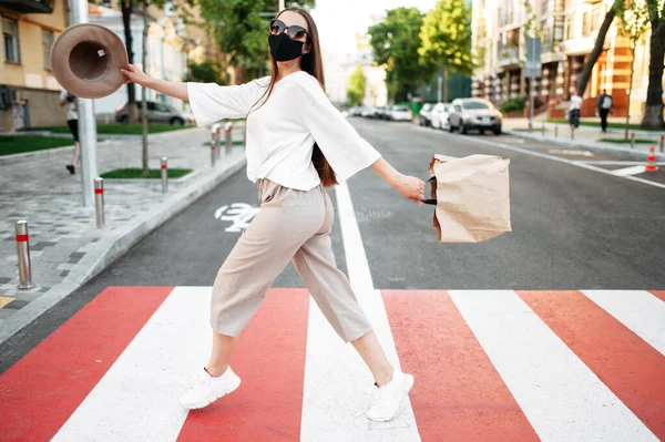Ragazza con una maschera sul viso cammina su un marciapiede — Foto Stock