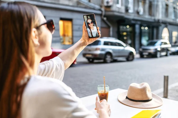 Menina bonita está tomando selfie no smartphone — Fotografia de Stock