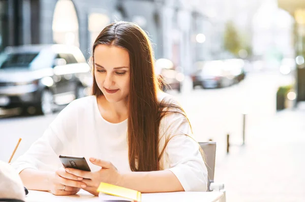 Atrakcyjna młoda kobieta rozmawia przez telefon na świeżym powietrzu — Zdjęcie stockowe