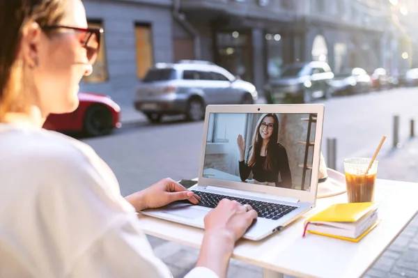 Mädchen benutzt Laptop für Videoanruf in Outdoor-Café — Stockfoto