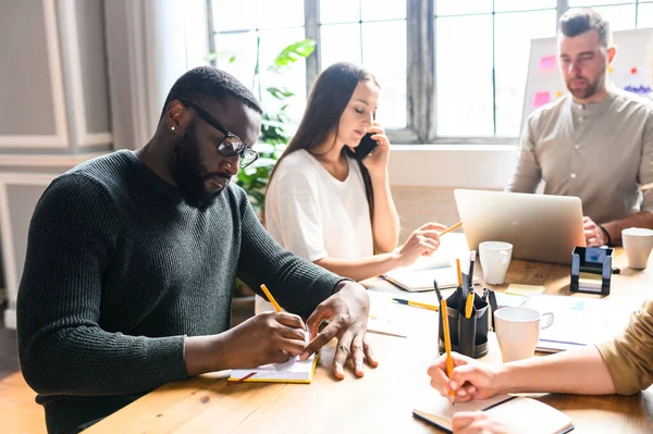 Trabajo de oficina de un equipo multirracial en pleno apogeo — Foto de Stock