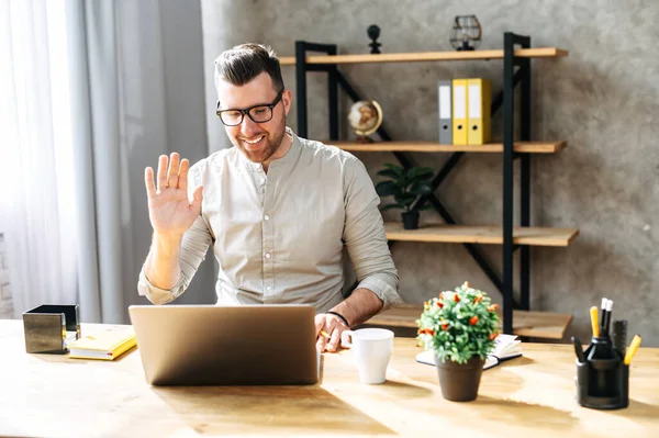 Aantrekkelijke kerel gebruikt laptop voor een videogesprek — Stockfoto