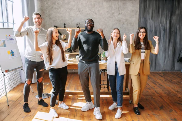 Uma equipe multirracial se alegra no cargo — Fotografia de Stock