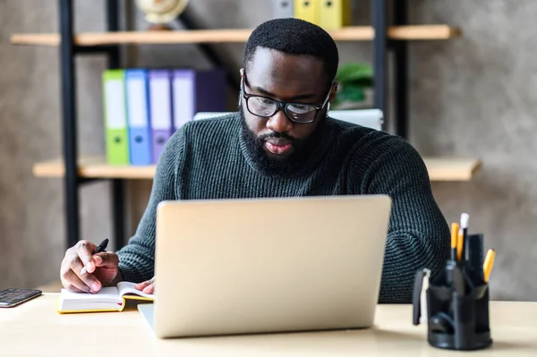 Un afroamericano usando un portátil en la oficina — Foto de Stock