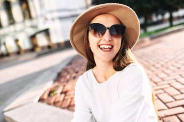 Şehir merkezinde şapkalı hoş bir kadın yürüyor.