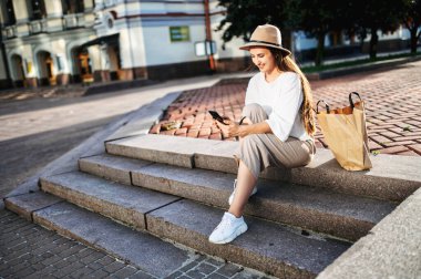 Şapkalı hoş kadın merdivenlerde oturuyor.