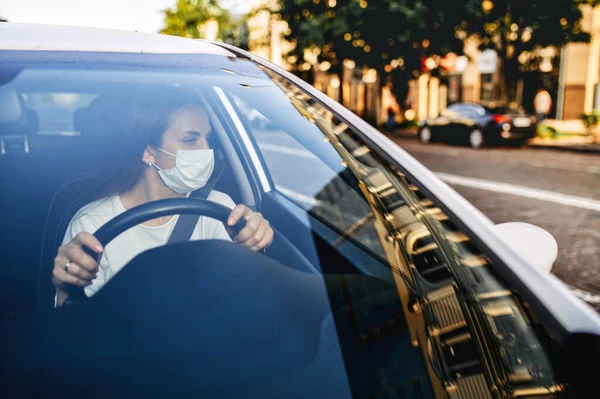 Жінка з медичною маскою водить машину — стокове фото