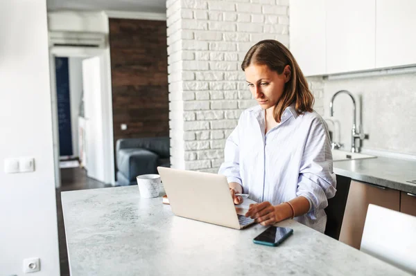 Junge Frau arbeitet von zu Hause aus mit Laptop — Stockfoto