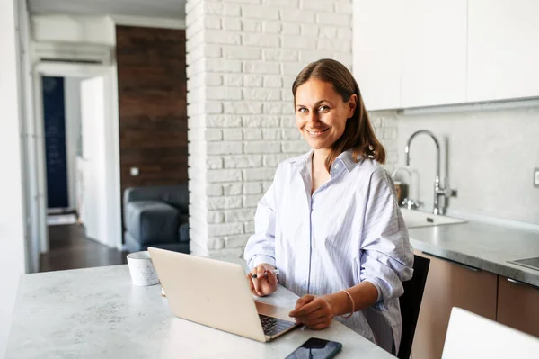 Junge Frau arbeitet von zu Hause aus mit Laptop — Stockfoto