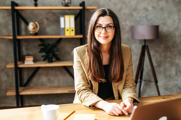 Junge Brünette erfolgreiche Frau sitzt am Tisch — Stockfoto