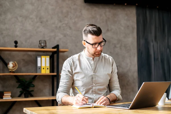 Serieuze jongeman werkt op een laptop — Stockfoto