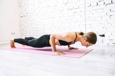 Evde antrenman yaparken kalasta sportif bir kadın.