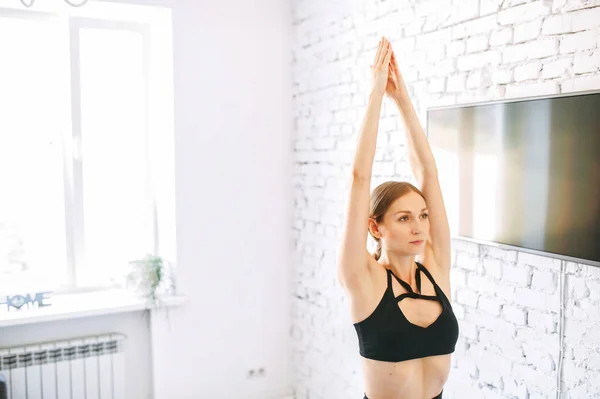 Junge Frau praktiziert Yoga zu Hause — Stockfoto