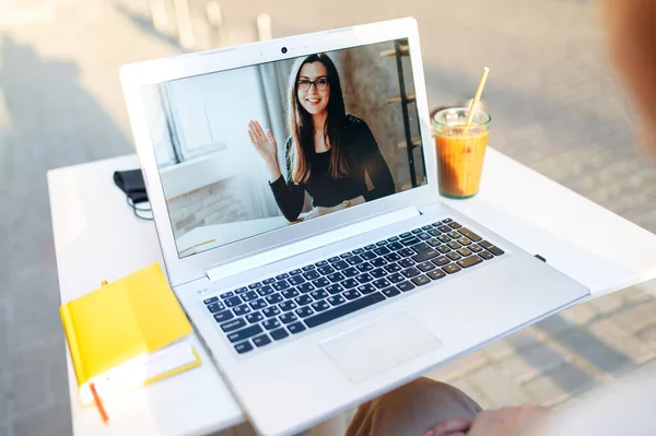 Dívka používá notebook pro videohovor ve venkovní kavárně — Stock fotografie