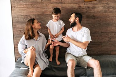 Mutlu anne, baba ve oğul kanepede oturuyor.