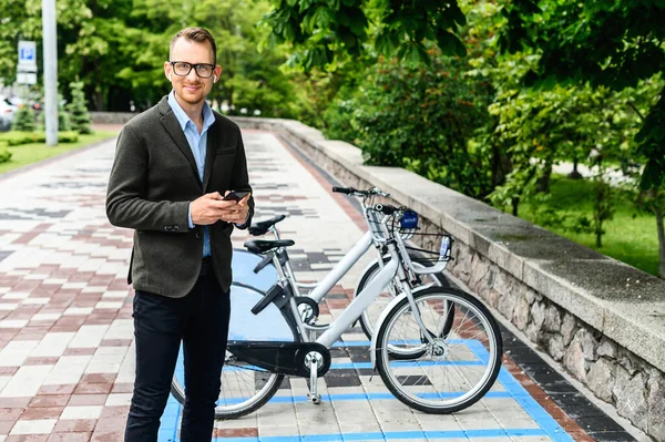 Un ragazzo in smart casual utilizzando app per noleggiare city bike — Foto Stock