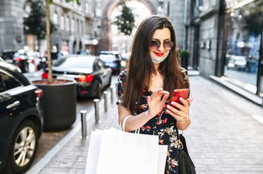 Koruyucu tıbbi maskeli bir kız alışverişe çıkıyor.