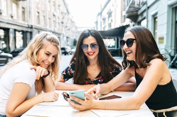 Молоді красиві дівчата сидять в кафе на вулиці — стокове фото
