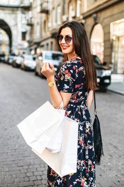 Chica alegre con bolsas de compras camina al aire libre — Foto de Stock