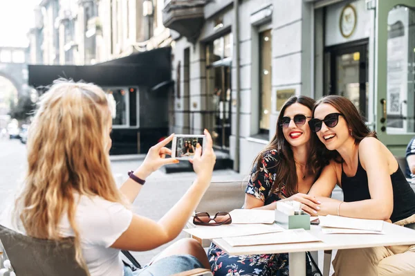 Jóvenes hermosas chicas se sientan en un café al aire libre — Foto de Stock