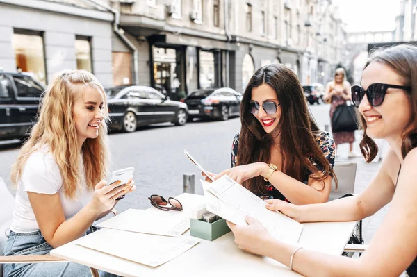 Jóvenes hermosas chicas se sientan en un café al aire libre — Foto de Stock