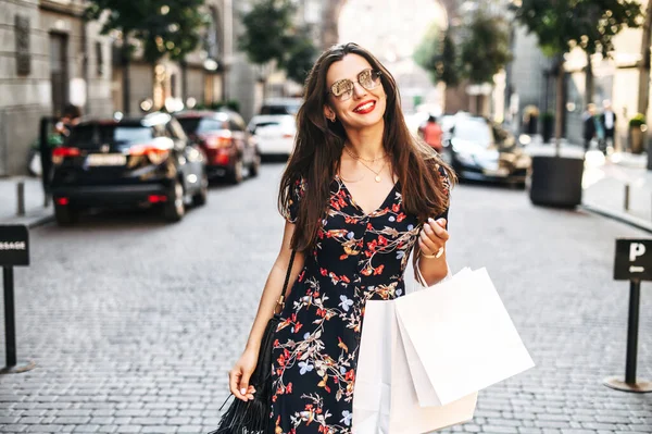 Chica alegre con bolsas de compras camina al aire libre — Foto de Stock