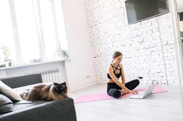 Online yoga practice of a young woman