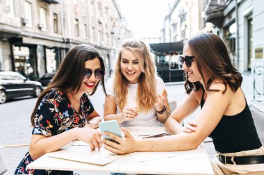 Genç güzel kızlar açık bir kafede oturuyor.