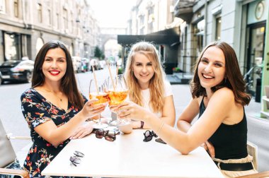 Kız arkadaşlar dışarıda bir kafede vakit geçirirler.