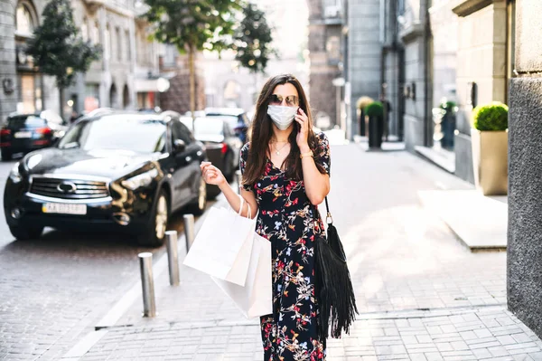 Una chica con una máscara médica protectora va de compras — Foto de Stock