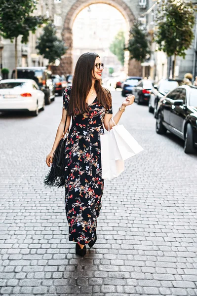 Chica alegre con bolsas de compras camina al aire libre — Foto de Stock